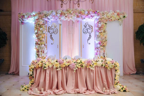 O conceito de uma celebração de casamento, celebração de amantes, decoração, flores, tecidos. A mesa dos recém-casados está decorada com flores, velas e tecidos. . — Fotografia de Stock