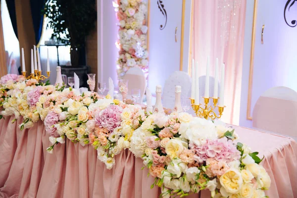 The concept of a wedding celebration, celebration of lovers, decor, flowers, fabrics. The table of the newlyweds is decorated with flowers, candles and fabrics. — Stock Photo, Image