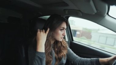Önden görünüm yakın çekim Genç esmer kadın şık bukleler vardır. Güzel makyaj senin araba kullanıyor, dikkatle yola görünüyor. İnsanlar, iş, road, hareket, mobilite kavramı.