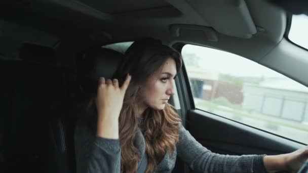 Vista frontale primo piano giovane donna bruna ha riccioli eleganti. Bellissimo make-up guida la vostra auto, guarda attentamente la strada. Concetto di persone, affari, strada, movimento, mobilità . — Video Stock