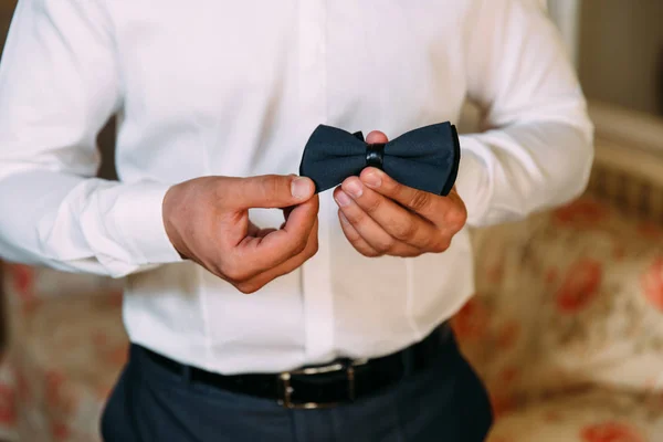 Close-up de uma moldura recortada de um homem de negócios elegante que vai a um casamento. Um homem de negócios em uma camisa branca como a neve veste um laço, usa um terno na moda, um cinto de couro . — Fotografia de Stock