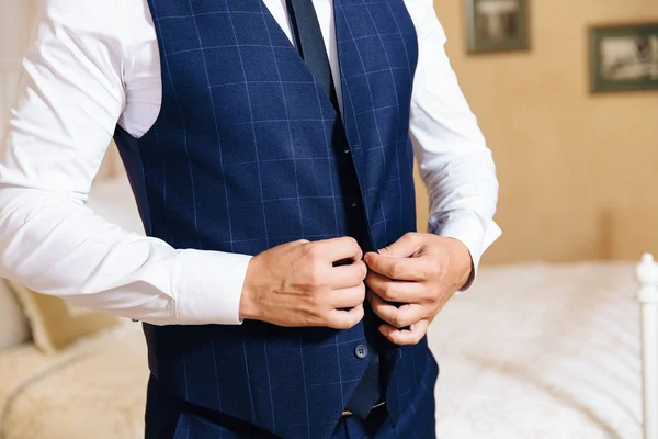 Primer plano de un marco recortado de un hombre elegante de negocios abotonando su chaqueta, de pie en una oficina elegante con reparación de diseño . — Foto de Stock