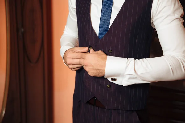 Крупный план обрезанной рамки бизнеса стильный мужчина застегивает куртку, стоя в стильном офисе с дизайнерским ремонтом . — стоковое фото