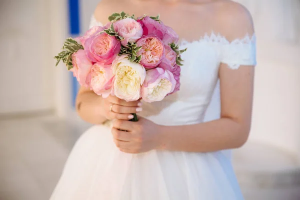 Detail oříznutého svatba rámu je nabídka kytici růží v rukou nevěsty. Dívka ve svatebních šatech drží květiny. — Stock fotografie