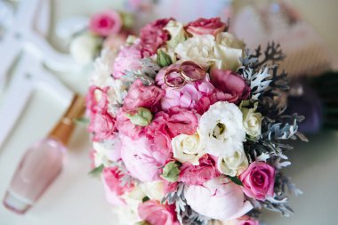 Parlak bir gelin gelin buketi, bir close-up üstten görünüm bir çiçek üzerinde nişan altın yüzük yatıyordu..