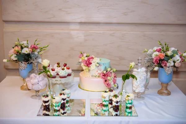 웨딩 케이크입니다. 캔디 바, 과자 및 디저트 테이블에 테이블. 맛 있는 컵 케이크와 함께 뷔페, 케이크 팝, 비스킷, 꽃. — 스톡 사진