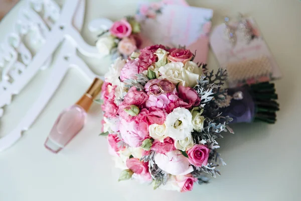 Bruiden set bruiloft accessoires, parfum en oorbellen bij bloemen achtergrond op tafel. Concept van juwelen. — Stockfoto