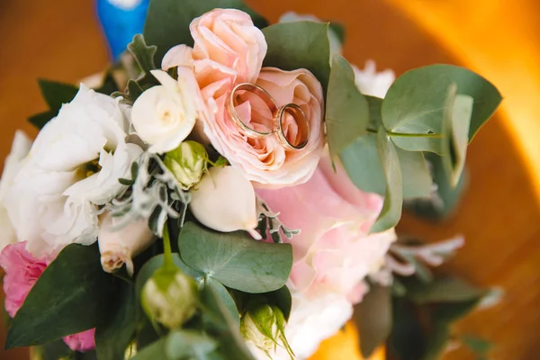 Bovenaanzicht van een close-up van een heldere bruids bruids boeket, op een bloem leggen betrokkenheid gouden ringen. — Stockfoto