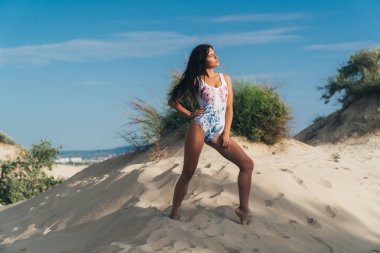 Issız bir kumsalda dinlenme bir çekici, seksi genç Avrupa kız kapalı gözleri zevkle, pürüzsüz cildi güneş ısıtıyor. Geri kalan deniz, seyahat, yaz, insanlar kavramı.