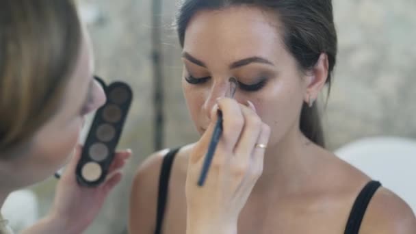 Strzał szczegół od góry do dołu make-up artist uzupełnia makijaż, posiada paletę nagie cienie suche w jego ręce, porady najjaśniejszy odcień powiek górnych i dolnych. — Wideo stockowe