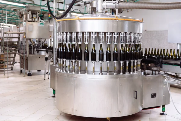 Glasflaskor på raden Automatisk transportband på champagne eller vin fabriken. Anläggning för buteljering alkoholhaltiga drycker. — Stockfoto