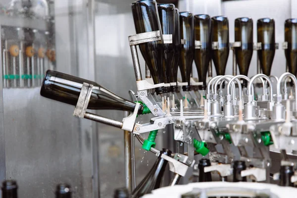 Glasflaskor på raden Automatisk transportband på champagne eller vin fabriken. Anläggning för buteljering alkoholhaltiga drycker. — Stockfoto
