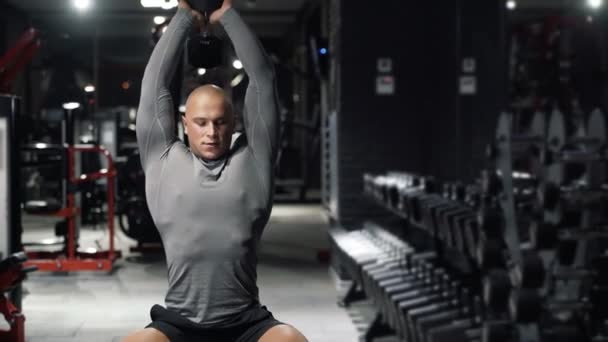 Silný svalnatý muž dělá sportovní cvičení s činkami, vlaky triceps v temné tělocvičně. Sportovní chlap se věnuje fitness. Koncept sport, zdraví. — Stock video