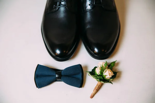 男装皮鞋, 领结和 boutonniere 在白色桌子背景。服装辅料商人. — 图库照片