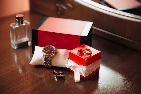 Чоловічі годинники, парфуми, наручні годинники, золоті кільця та запонки на тлі коричневого столу. Аксесуари для одягу бізнесмен. Концепція аксесуарів для столу в день весілля . — стокове фото