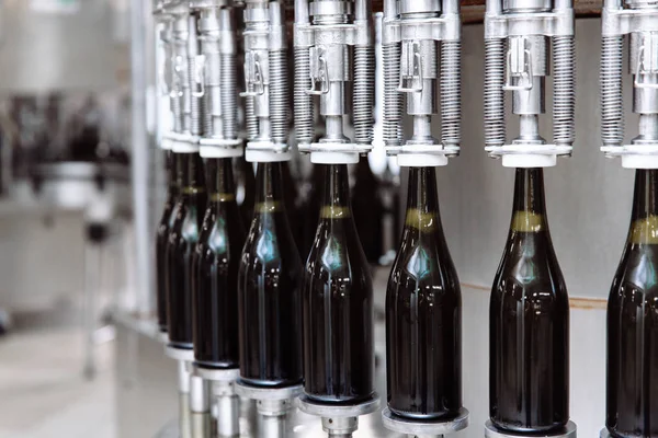 Botellas de vidrio en la línea transportadora automática en la fábrica de champán o vino. Planta para embotellar bebidas alcohólicas . — Foto de Stock