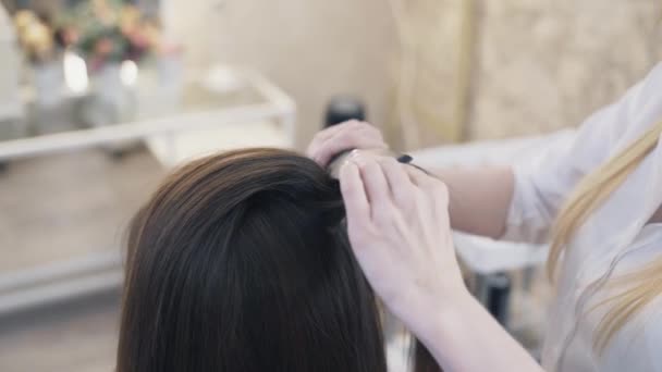 クローズ アップ、スローモーションの女性美容師は、髪を圧着髪アイロンを使用してクライアントに散髪を行います。仕事でプロの美容師. — ストック動画