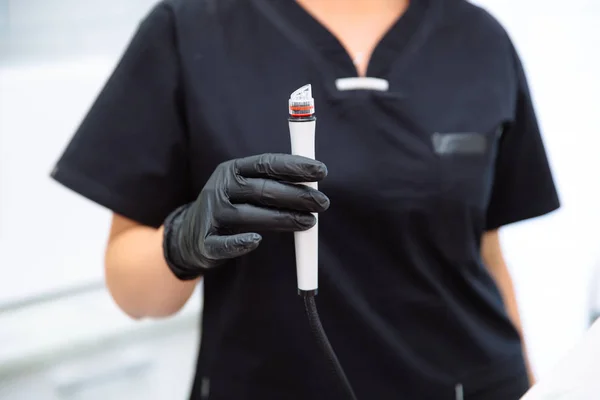 Manípulo de close-up de aparelho de hidropeeling nas mãos de um médico esteticista . — Fotografia de Stock