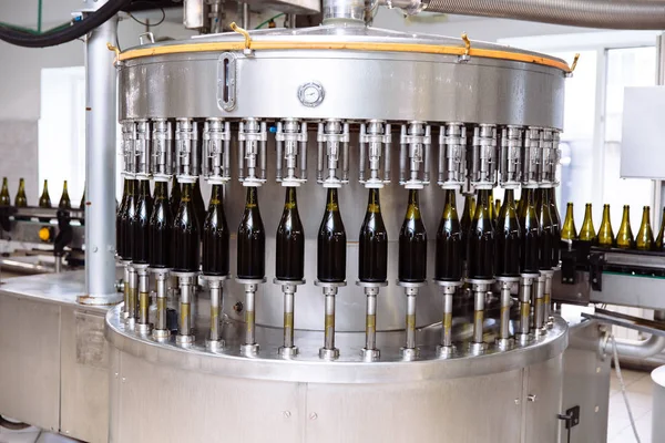 Скляні пляшки на лінії автоматичного конвеєра на шампанському або винному заводі. Рослина для розливу алкогольних напоїв . — стокове фото