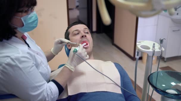 Zbliżenie kobieta dentysty bada pacjenta zęby z doustne kamera. Leczenie i profilaktyka chorób zębów, próchnica, pojęcie zdrowia. — Wideo stockowe