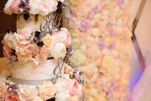 Крупним планом багаторівневий весільний торт, прикрашений квітами, стоїть на столі. Концепція їжі, солодощів та десертів на вечірці . — стокове фото