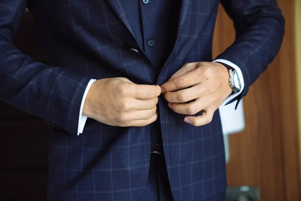 Primer plano de negocios hombre elegante abotonamiento de su chaqueta, de pie en una oficina con estilo con la reparación del diseñador . —  Fotos de Stock