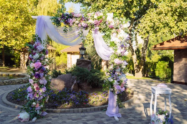 Bryllupsdag, ceremoni sted for bruden og brudgommen, indretning, blomster. Begrebet indretning, bryllup bue er dekoreret med blomster - pink og hvide pæoner . - Stock-foto