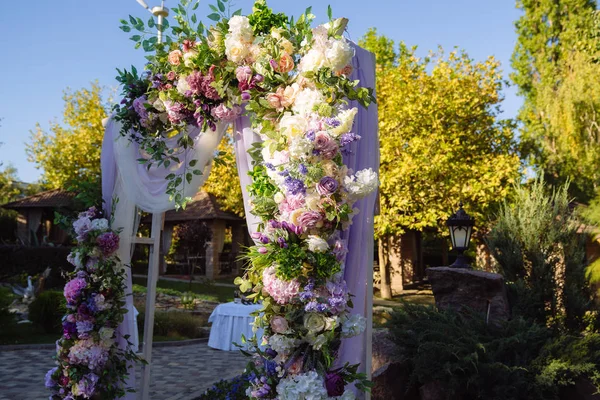 Bryllupsdag, ceremoni sted for bruden og brudgommen, indretning, blomster. Begrebet indretning, bryllup bue er dekoreret med blomster - pink og hvide pæoner . - Stock-foto