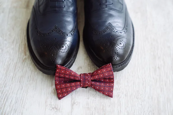 Zapatos de cuero para hombre, pajarita y boutonniere sobre un fondo de mesa blanco. Accesorios de ropa hombre de negocios . — Foto de Stock