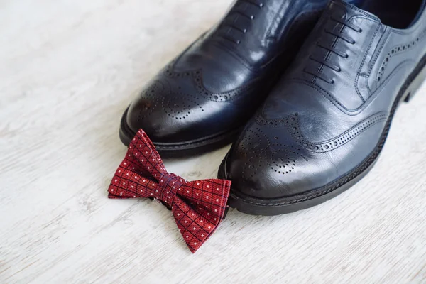 Чоловіче шкіряне взуття, краватка-мішок і бутоньєрка на білому тлі столу. Аксесуари для одягу бізнесмен . — стокове фото