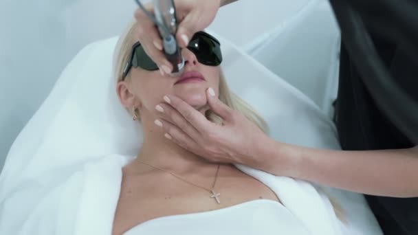 Jeune blonde fait épilation au laser dans le salon de beauté, steadicam shot — Video