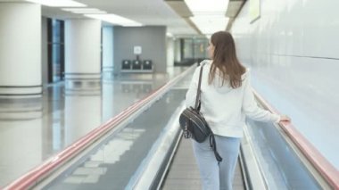 Arka görünümü kadın spor sırt çantası ile gider devam Havaalanı'nda geçit.