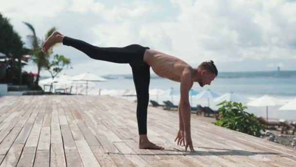 Uomo sportivo che fa esercizio di yoga in piedi su una gamba con bella vista sullo sfondo — Video Stock