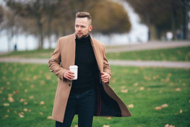 Sakallı yakışıklı genç Park, kopya alanı Kupası kahve içme güneş gözlüğü