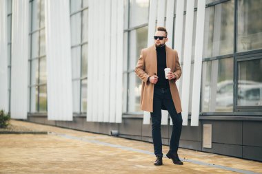 Sakallı yakışıklı genç paket servisi olan restoran kahve iş merkezine yakın tutarak güneş gözlüğü.