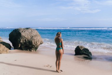 Arka görünümü ince kadın mayo ayakta okyanus plaj