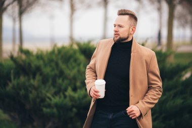 Park, kopya alanı Kupası içme kahve yakışıklı sakallı genç adam