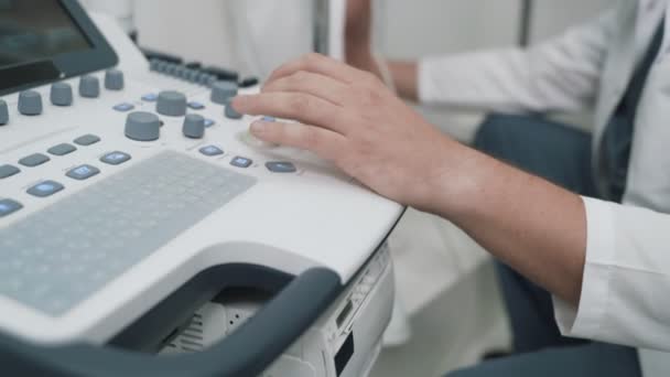 Detail přístroje pro výzkum ultrazvuk, zatímco phlebologist funguje na něm — Stock video