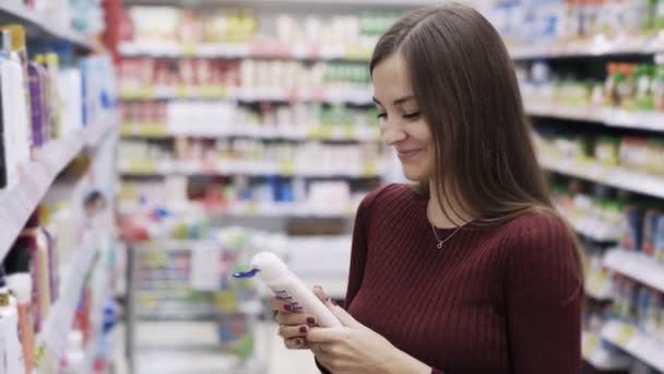 Video divertente, donna prende gel doccia, annusa e ride nel reparto di cosmetici del supermercato — Video Stock