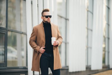 Sakallı yakışıklı genç paket servisi olan restoran kahve iş merkezine yakın tutarak güneş gözlüğü.