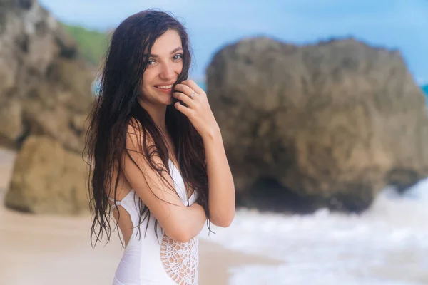 Портрет счастливой улыбающейся женщины с длинными волосами, отдыхающей на пляже — стоковое фото