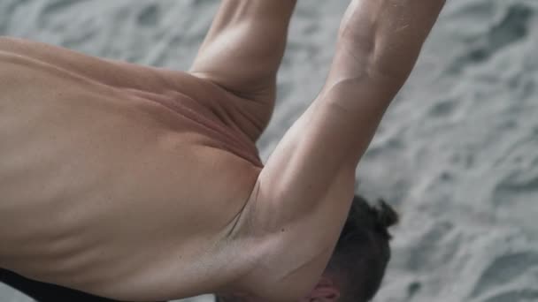 Atletisk man gör yoga pose och pilates övningar på sandstrand — Stockvideo