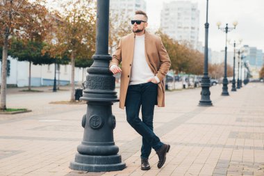 Sakal ayakta kahverengi ceket güneş gözlüğü ile sokakta ile şık adam.