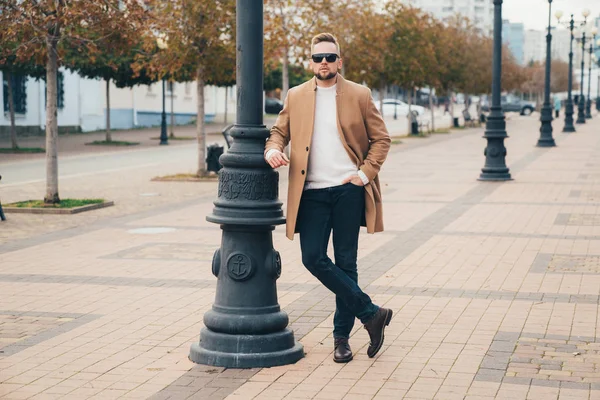 Stylish man with beard standing on street in brown coat with sunglasses. — Φωτογραφία Αρχείου