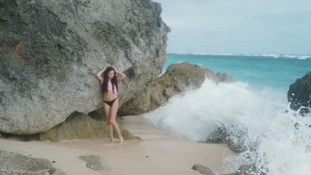 Pomalý pohyb, portrét krásné smyslné dívky v plavkách pózuje na pláži s vlnami na pozadí, steadicam zastřelil — Stock video