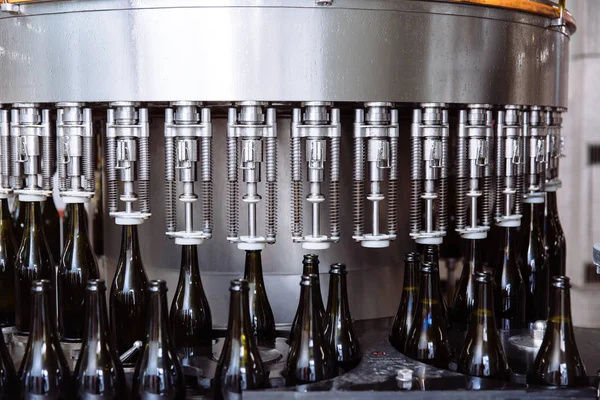 Glasflaskor på raden Automatisk transportband på champagne eller vin fabriken. Anläggning för buteljering alkoholhaltiga drycker. — Stockfoto