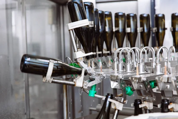 Glasflaskor på raden Automatisk transportband på champagne eller vin fabriken. Anläggning för buteljering alkoholhaltiga drycker. — Stockfoto