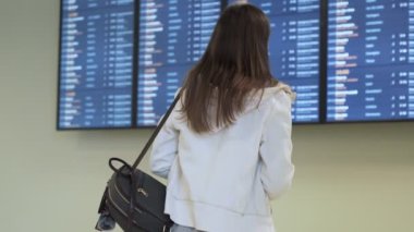 Arka görünümü turist kadının uluslararası havaalanında takvim bilgi yönetim kurulu denetleme