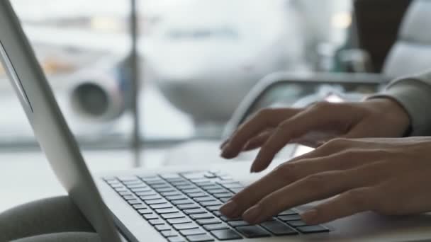 Le mani di primo piano di donna stampano qualcosa su computer portatile a sala di partenza in sfondo di aeroporto di aereo in finestra — Video Stock