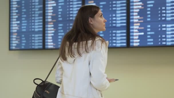 Vue de l'arrière de l'horaire des vols de contrôle féminin du voyageur à bord du départ à l'aéroport — Video